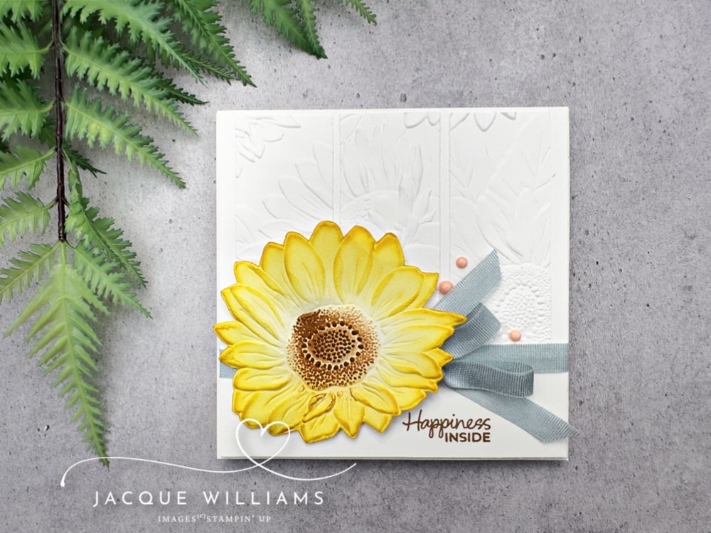 Clean and simple handmade card featuring the Stampin’ Up! Sunflower Embossing Folder, with a bold yellow die-cut sunflower, subtle embossed white background, and soft blue ribbon—perfect for cardmaking inspiration, embossing folder techniques, and papercraft project ideas.